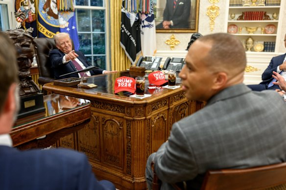 Trump displays “Trump 2028” hats during a leaders meeting.