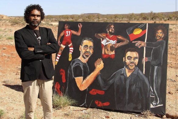 Vincent Namatjira with his 2020 Archibald Prize-winning portrait of Adam Goodes.