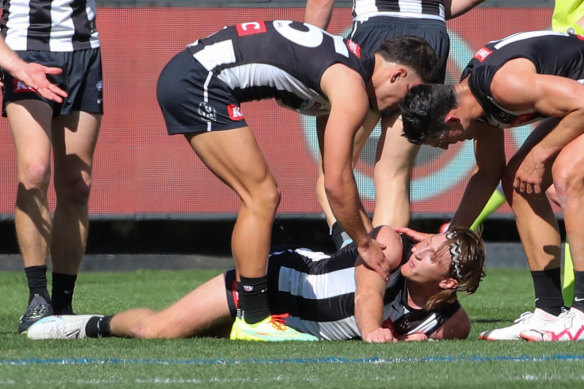 Teammates check on Nathan Murphy before he was subbed off.