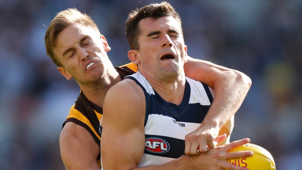 Mark O’Connor of the Cats and Harry Morrison of the Hawks compete for the ball.