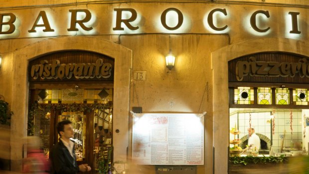 People walk by the Barroccio restaurant in Rome, a trattoria raided in 2017 as an alleged fronts for money-laundering operations for the `ndrangheta.