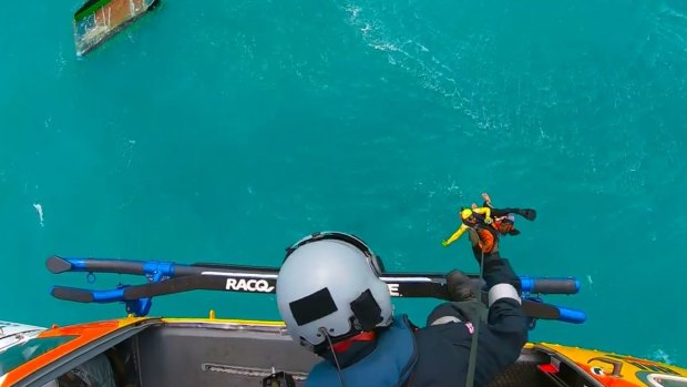 RACQ CQ Rescue winches American tourist Levi Verwoest from his overturned catamaran near Cape Palmerston, Koumala, Queensland.