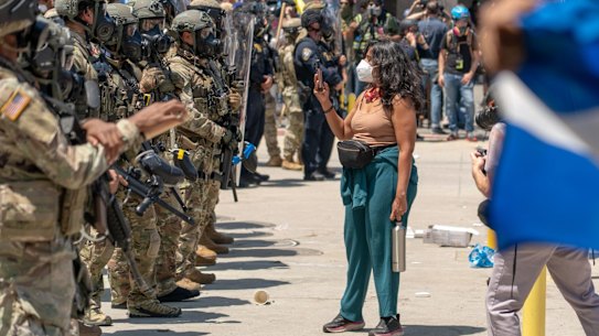 A protester confronts National Guard soldiers outside a federal building during a demonstration in LA on Sunday.