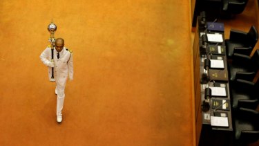 Sri Lanka's sergeant at arms Narendra Fernando walks carrying the mace in the well of the house past empty seats of President Maithripala Sirisena and disputed Prime Minister Mahinda Rajapaksa at the beginning of the parliamentary session in Colombo, Sri Lanka. 