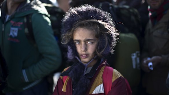 Yazidi refugee Salma Bakir, 9, from Iraq, waits with her family to be permitted by Macedonian police to board a train heading to the Serbian border.