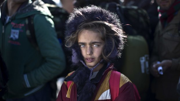Yazidi refugee Salma Bakir, 9, from Iraq, waits with her family to be permitted by Macedonian police to board a train heading to the Serbian border.
