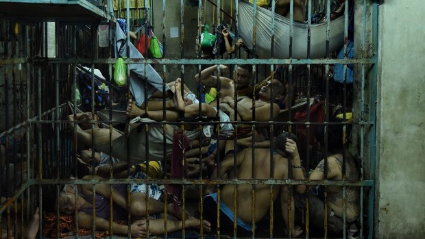 Prisoners inside an over crowded cell in Manila Police Headquarters, Philippines as a result of Duterte's drug crackdown. So they can sleep, prisoners here rotate positions.