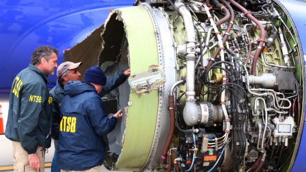 Investigators examine damage to the engine of the Southwest Airlines plane that made an emergency landing in Philadelphia in April.