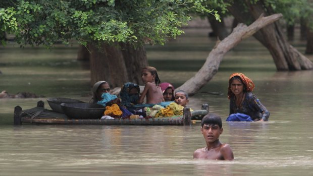 Villagers wade through floodwaters in Rajanpur, Pakistan,  in 2015.