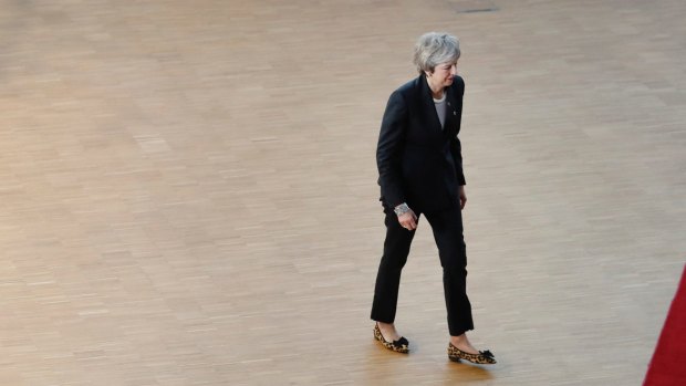 British Prime Minister Theresa May walks away after she spoke with the media at an EU summit in Brussels.