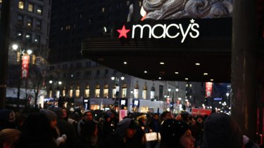 Pedestrians pass in front of a Macy's Inc. department store in New York, US, 