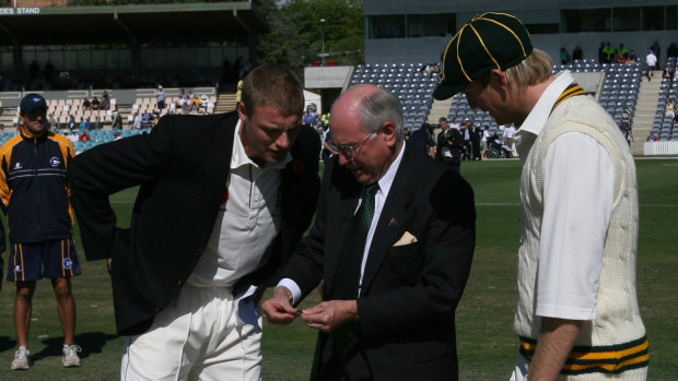 Former prime minister John Howard tosses the coin.