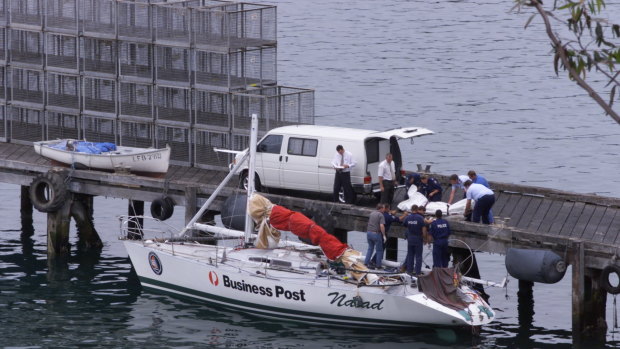 Police remove the bodies of two crewmen from the Business Post Naiad which was towed into Eden.