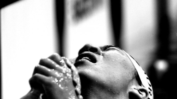 A Korean swimmer prays after his 100 metre freestyle heat in the Sydney Olympics.