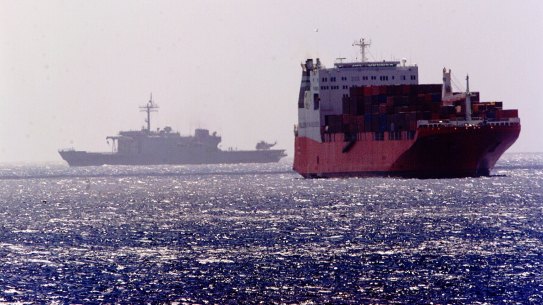 An Australian navy ship passes by the MV Tampa off Christmas Island in 2001.