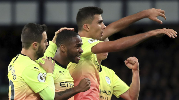 Manchester City's Raheem Sterling, centre, celebrates scoring his side's third goal at Goodison Park.