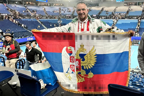 Sasha Karaman at this year’s Australian Open, holding a half-Serbian, half Russian flag with nationalist slogans, which The Age has pixelated.