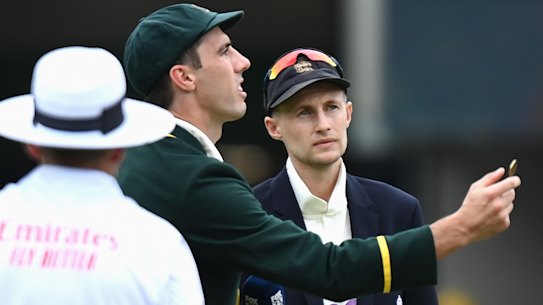 Australian captain Pat Cummins tosses the coin as England captain Joe Root calls.