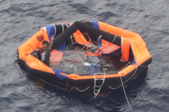 The 30-year-old can be seen on the left of the life raft waving for help.