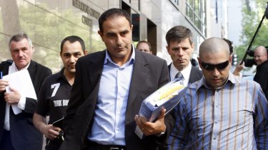 Rob Karam (centre) carrying a blue folder, outside Melbourne Magistrates Court in 2009.