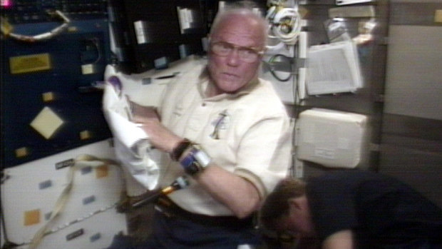 John Glenn works on experiments in the mini-lab aboard the Space Shuttle Discovery on October 31, 1998.