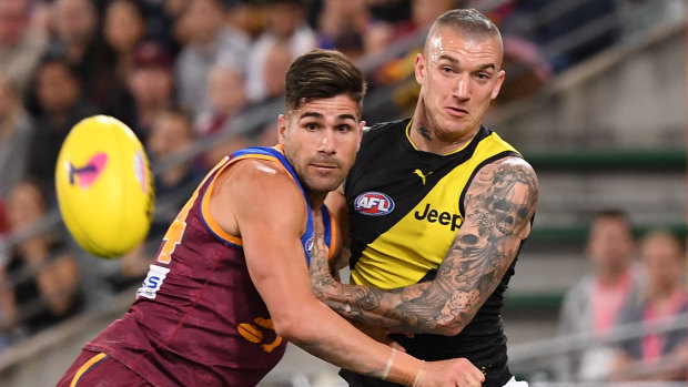 Good luck: Lions defender Marcus Adams tries his best to compete with a rampaging Dustin Martin at the Gabba on Saturday night. 