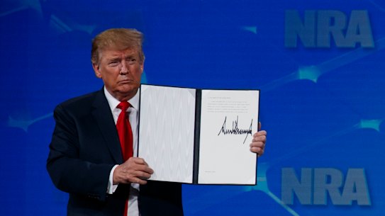 US President Donald Trump holds up a letter to the Senate about the UN Arms Trade Treaty as he speaks to the annual meeting of the National Rifle Association. 