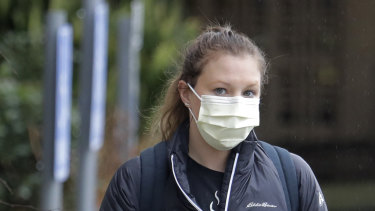 A woman wearing a mask walks away from the Life Care Centre in Kirkland, near Seattle, Washington state.