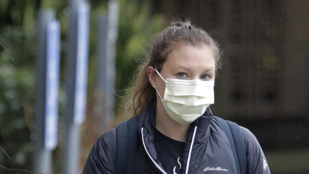A woman wearing a mask walks away from the Life Care Centre in Kirkland, near Seattle, Washington state.