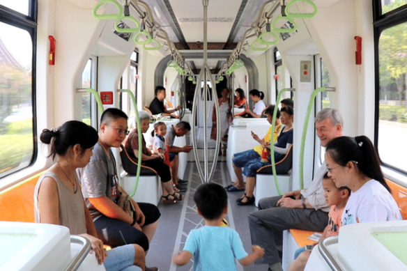 A child runs along the trackless tram with the author looking on. 