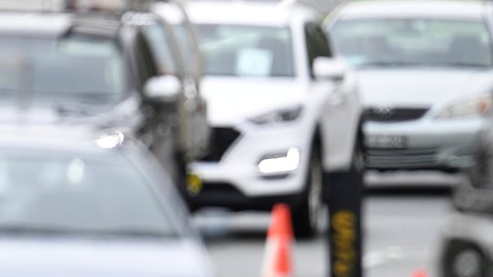 Vehicles queued up at a police checkpoint at the Queensland/NSW border in Coolangatta on Monday.