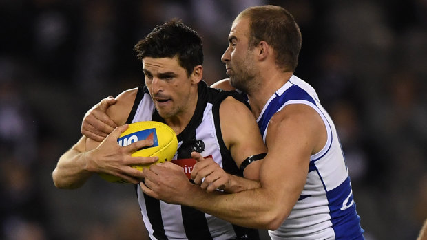 Wrapped up: Pies captain Scott Pendlebury is stopped in his tracks by North's Ben Cunnington.