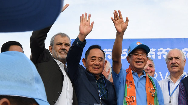 Cambodian PM Hun Sen, right, stands with the International election observers.