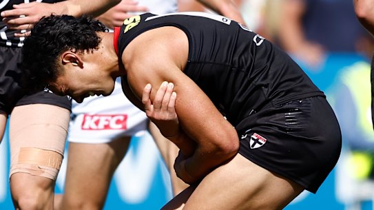 Mitch Owens clutches at his shoulder.