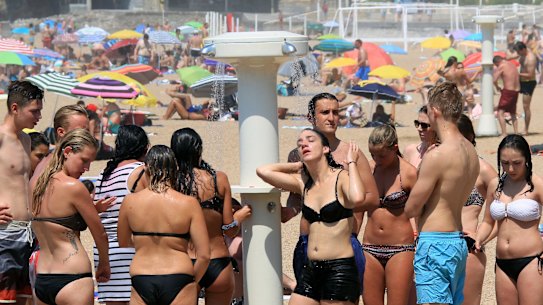 People line up to take a shower on a beach in Biarritz, in south-west France.