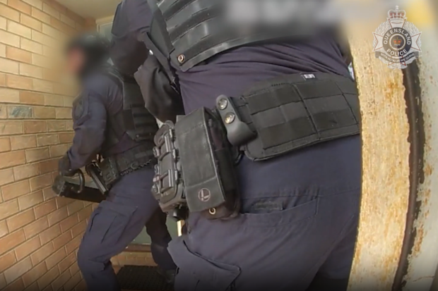 Police prepare to force entry to a residence as part of a search warrant.