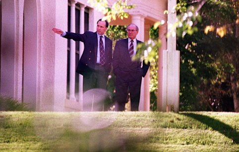 Your turn to mow the lawn: the deposed occupant of the Lodge, Paul Keating, shows the garden to its new tenant, John Howard, in March 1996. 