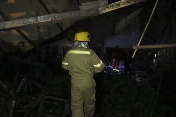 This image made from video shows a civil defence team member walks through the site of a fatal fire at a wedding celebration, in the district of Hamdaniya in Mosul, Iraq.