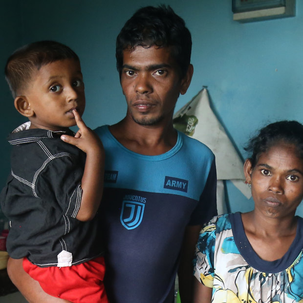 Sandun Rohitha with his wife Niluka and son Yenura. Without gas for
the past eight months, they
have been using firewood
and plastic sheets to cook.