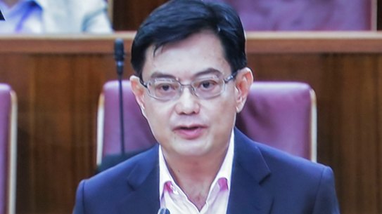 A man watches a television showing Singapore's Deputy Prime Minister Heng Swee Keat annoucing a major new economic stimulus package.
