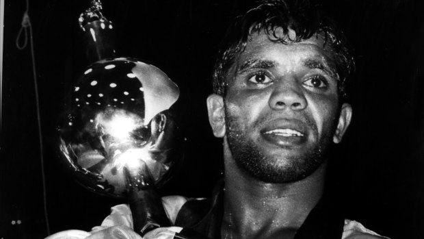 A weary eyed Lionel Rose clutches his world title trophy after beating Alan Rudkin in Melbourne 1969