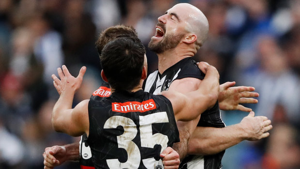 Steele Sidebottom and his Magpies teammates celebrate a key late goal against North Melbourne.
