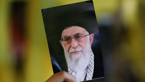 A Hezbollah supporter holds a portrait of Iran's supreme Leader Ayatollah Ali Khamenei.