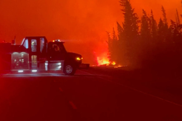 A vehicle is parked near a burning wildfire in Hay River, Canada, this week.