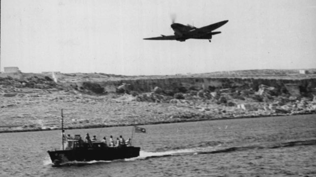 A Spitfire flies over the Malta-based high-speed launch during the war.