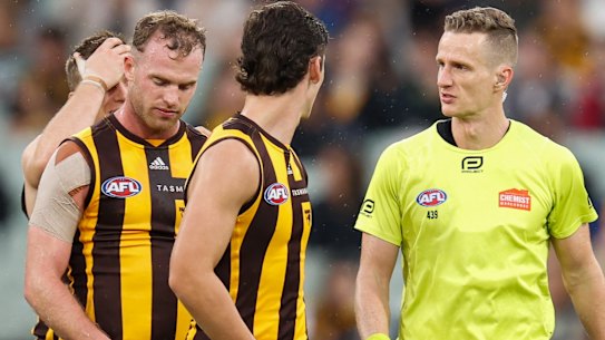 Tom Mitchell speaks with field umpire Hayden Gavine after a 50-metre penalty was awarded to Geelong.