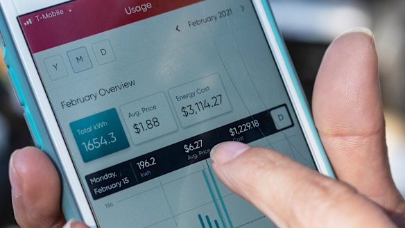 Ivet Cantu points to her electricity bill from Griddy energy on an app showing her energy cost of $US3114 ($3950), during recent severe cold weather outside of her home in Dallas. 