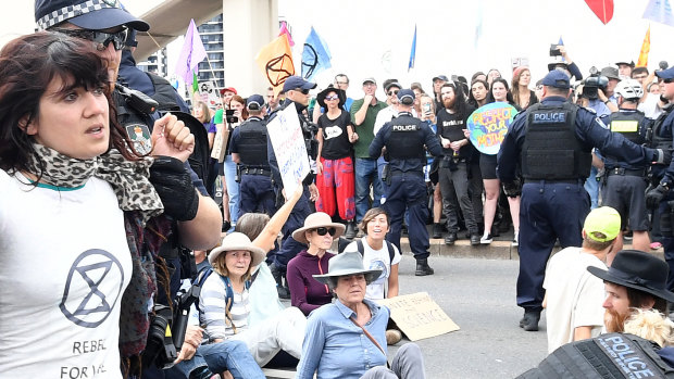 Police arrest activists from the Extinction Rebellion (XR) group after they took over the William Jolly Bridge during protests in Brisbane on Friday.