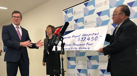 Federal minister Alan Tudge (left) was presented with a donation by Di Sanh Duong (right) in 2020.
