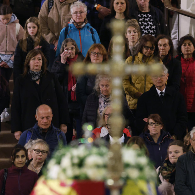 People queue to walk past the coffin of Queen Elizabeth II as it lies in state on the catafalque in Westminster Hall.